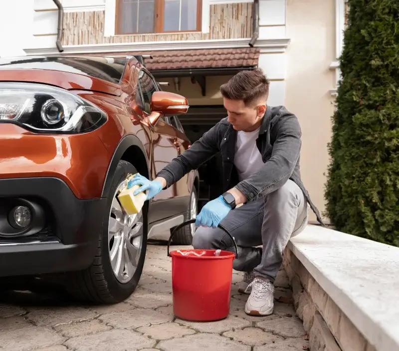 Lavage auto à domicile Saint-Jean-Poutge : professionnel intervenant sur un véhicule